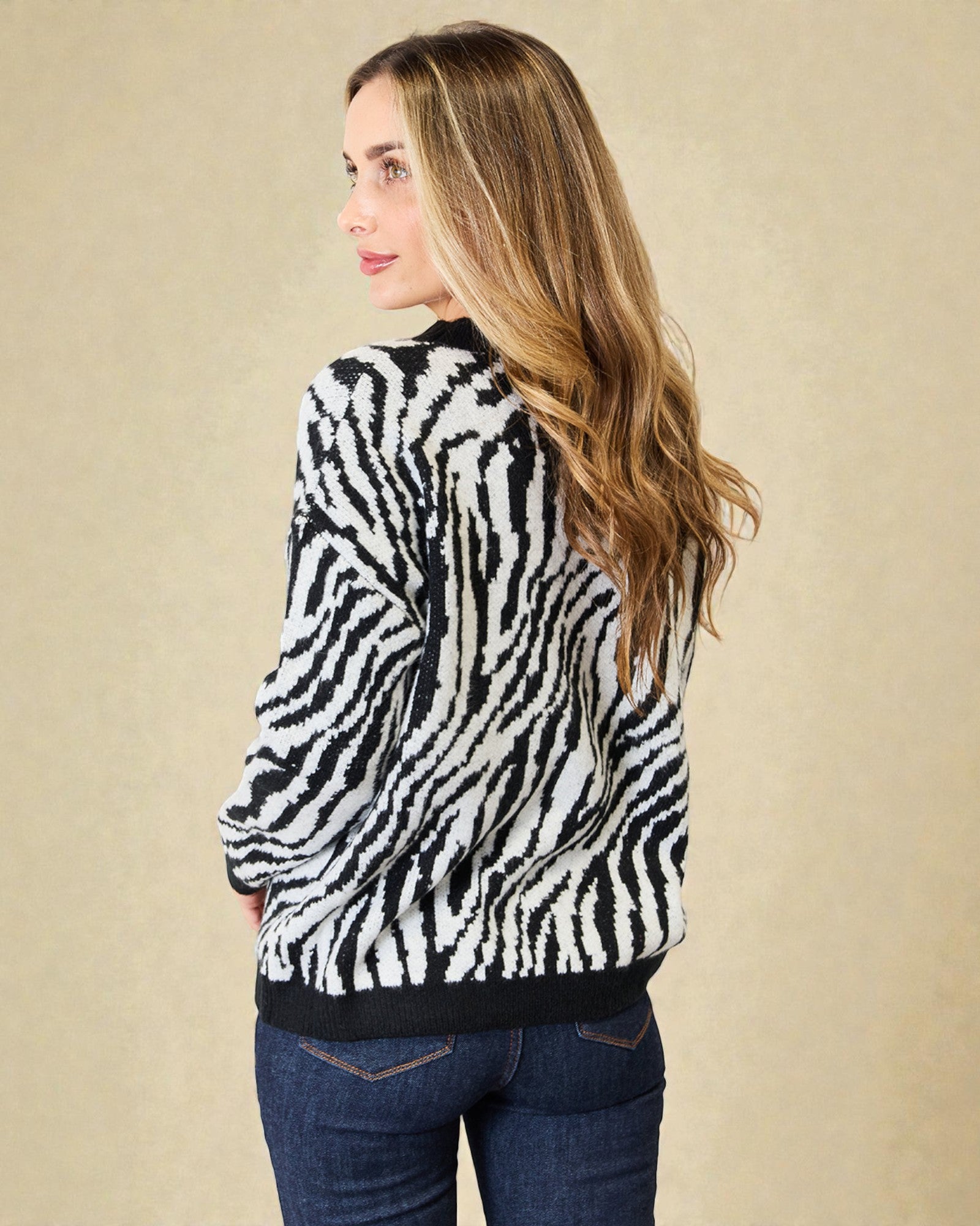 Woman wearing a zebra print sweater against a beige background