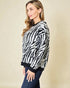 Woman wearing a zebra pattern sweater against a beige background