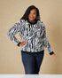 Woman wearing a zebra print sweater against a beige background