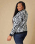 Woman wearing a zebra print sweater against a beige background