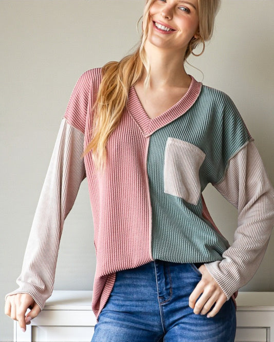 Woman wearing a colorful sweater with a neutral background