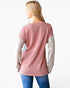 A woman shown from the back wearing a long-sleeve ribbed knit top with a dusty pink body and light beige sleeves, paired with blue jeans against a plain white background.