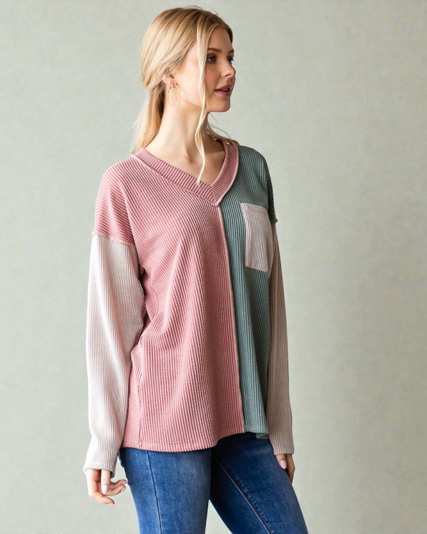 Woman wearing a colorful sweater with a neutral background