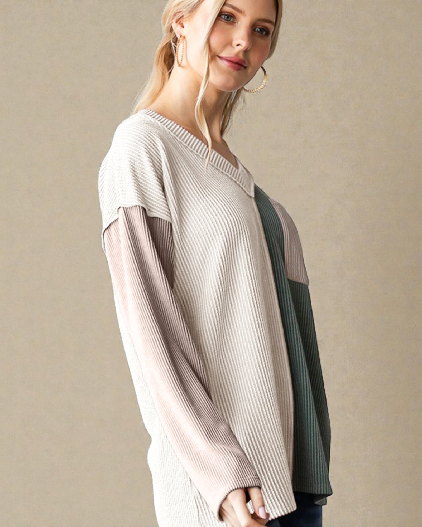 Woman wearing a light-colored sweater with a neutral background