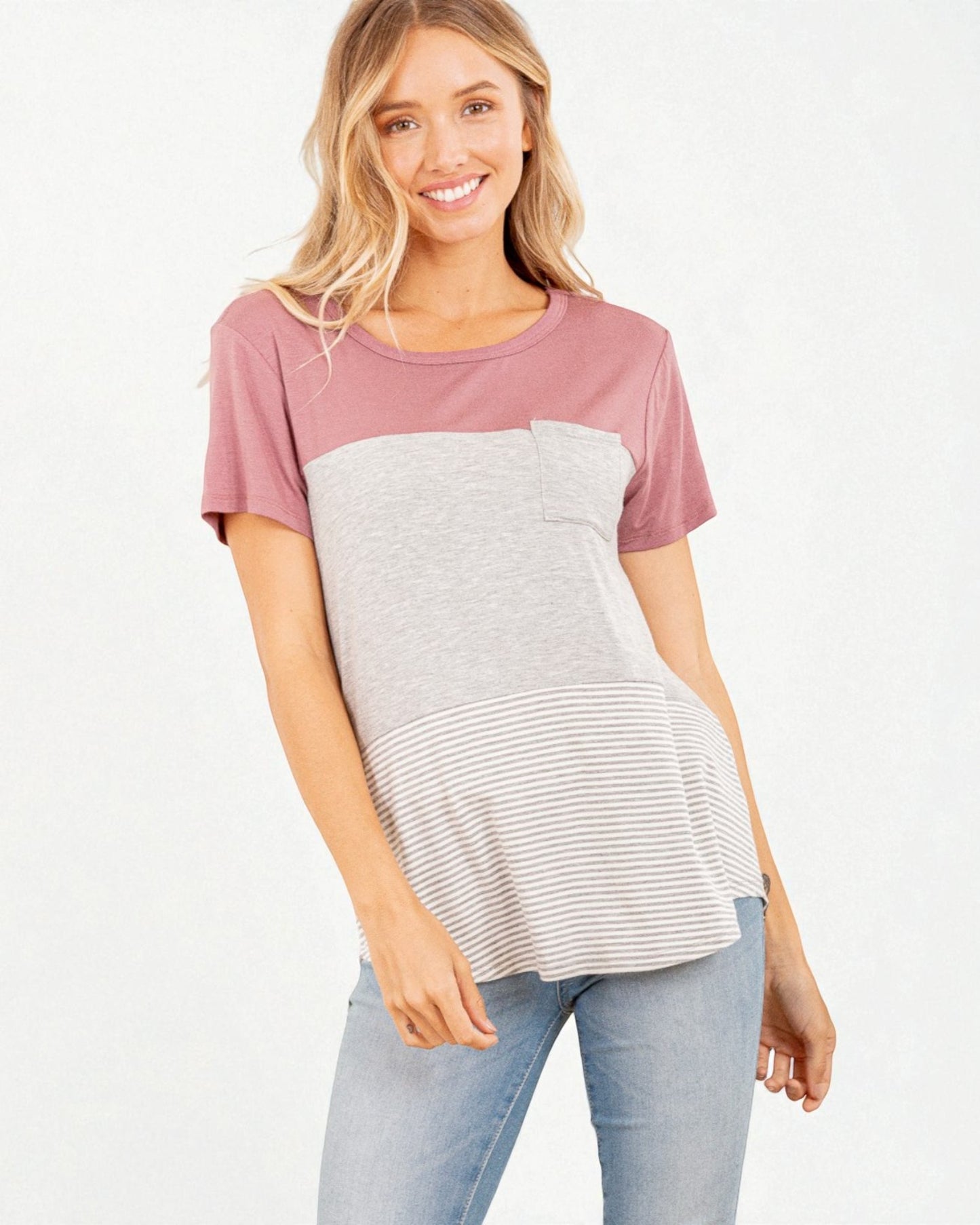 Woman wearing a two-tone shirt with pink sleeves and a grayish-white body on a white background