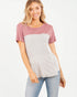 Woman wearing a two-tone shirt with pink sleeves and a grayish-white body on a white background