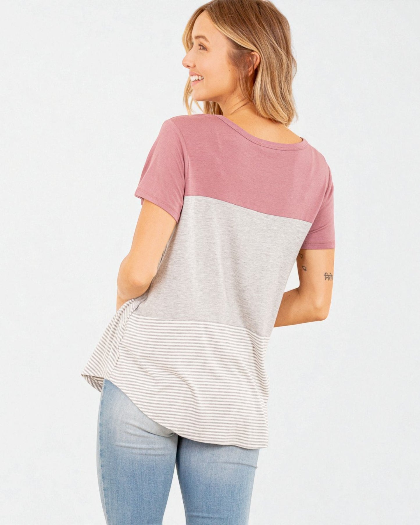 Woman wearing a two-tone t-shirt with pink and gray colors on a white background