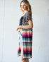Woman wearing a leopard print top and colorful striped skirt against a white background