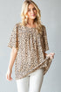Woman wearing a leopard print blouse against a gray background