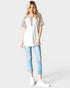 Woman wearing a white top with leopard print sleeves and light blue jeans on a white background