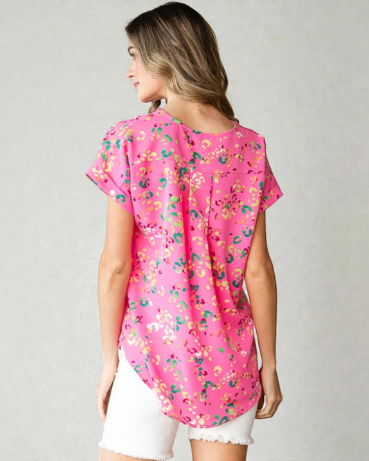 Woman wearing a pink floral blouse on a plain background