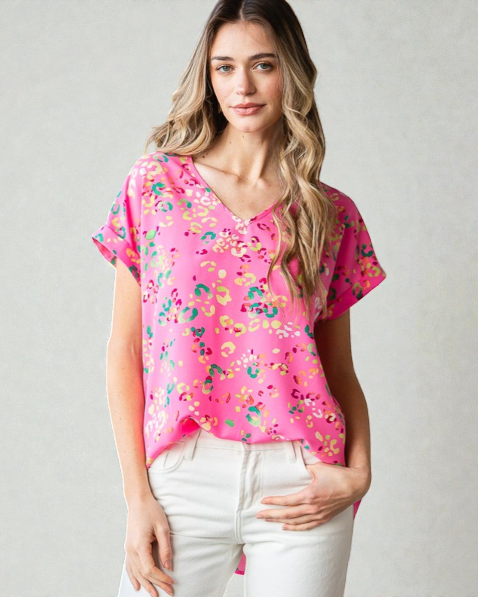 Woman wearing a pink floral blouse against a plain background