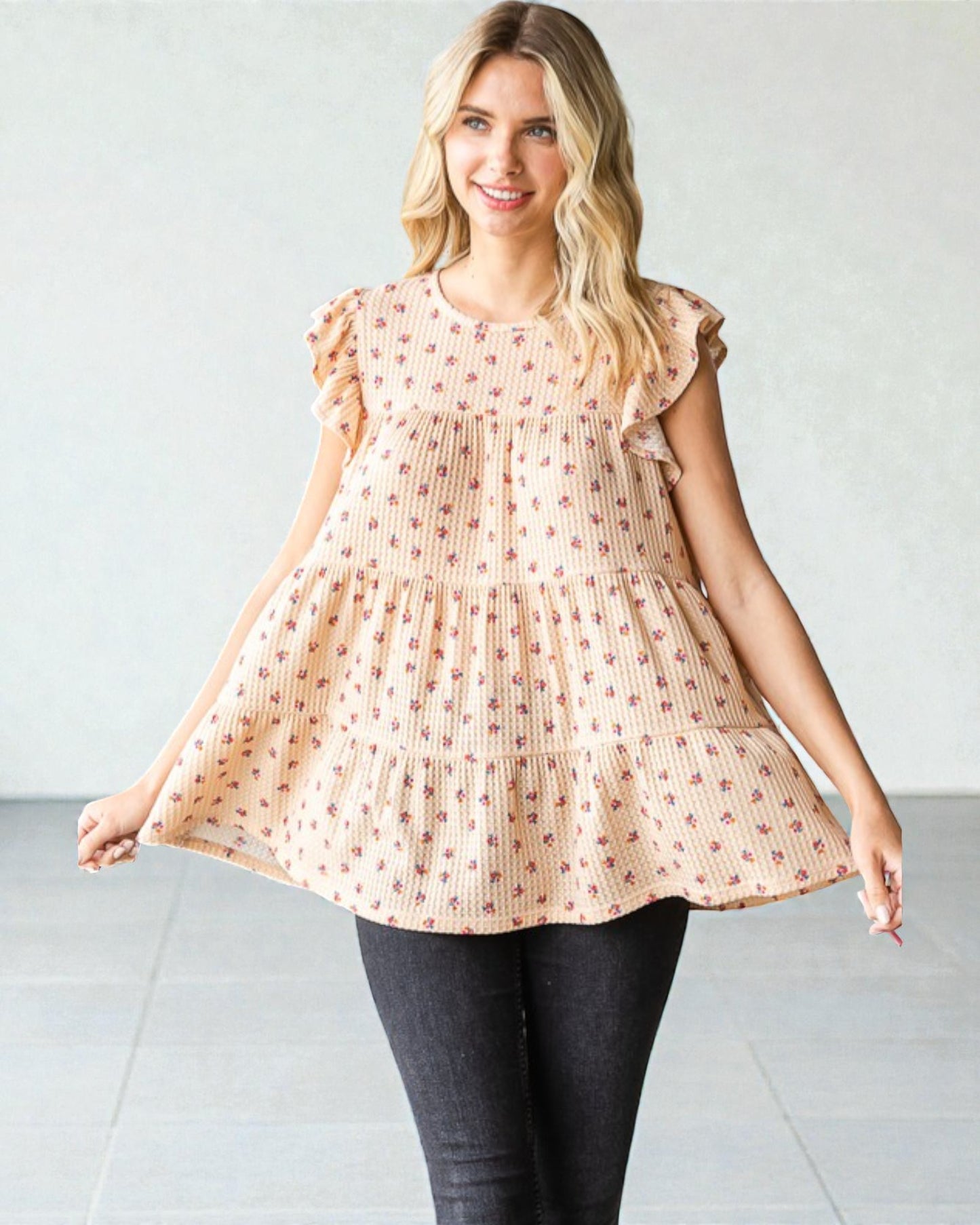 Woman wearing a peach-colored dress with ruffled sleeves against a white background