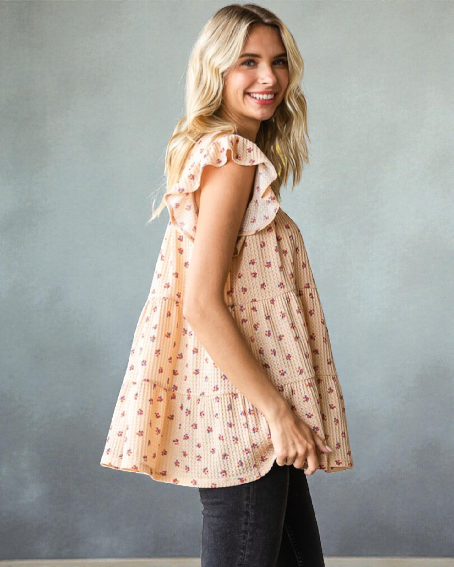 Woman wearing a patterned blouse against a gray background