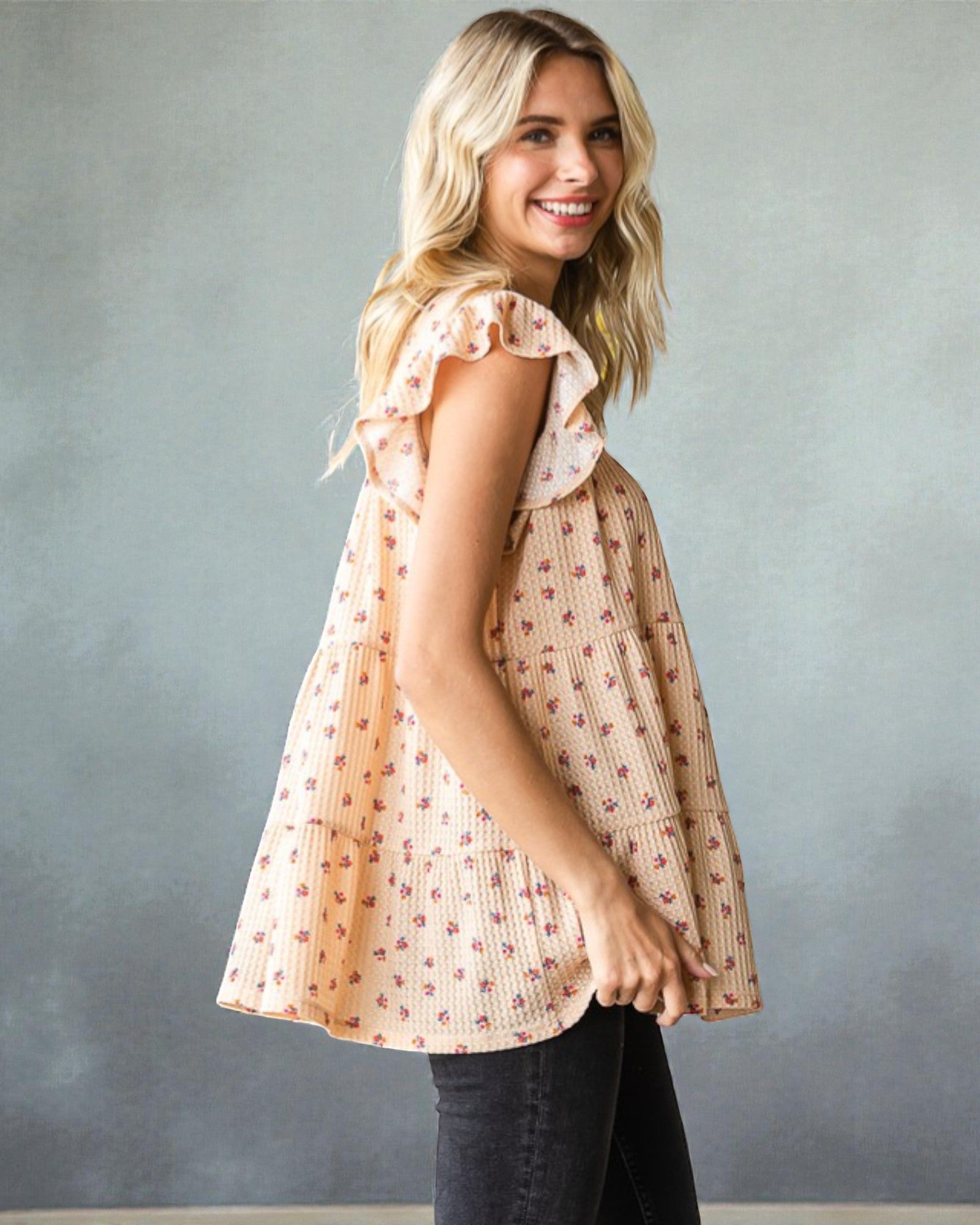 Woman wearing a patterned blouse against a gray background