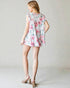 Woman wearing a floral dress against a plain background