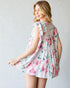 Woman wearing a floral dress against a plain background