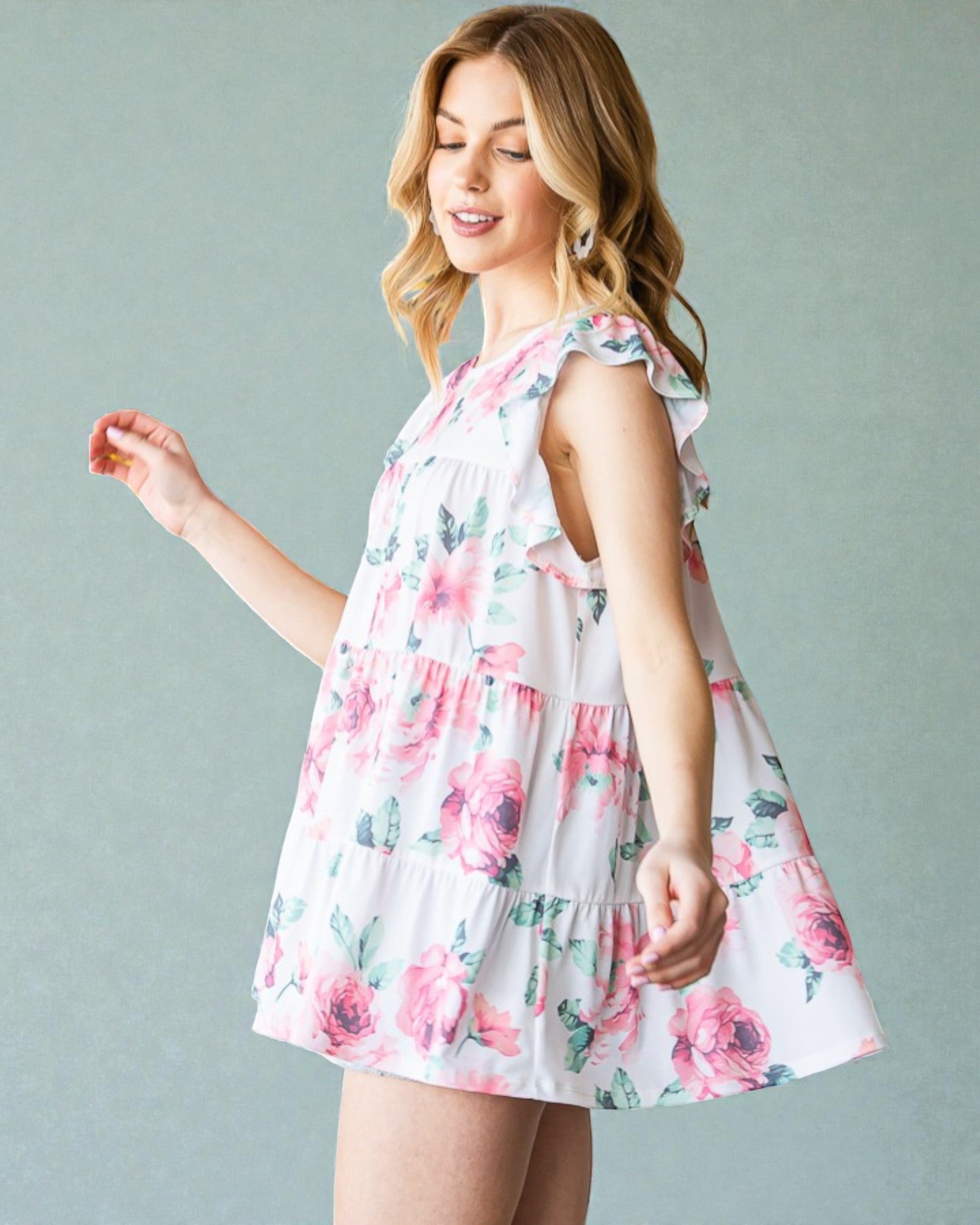Woman wearing a floral dress against a plain background