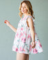 Woman wearing a floral dress against a plain background