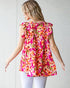 Woman wearing a pink floral top against a white background