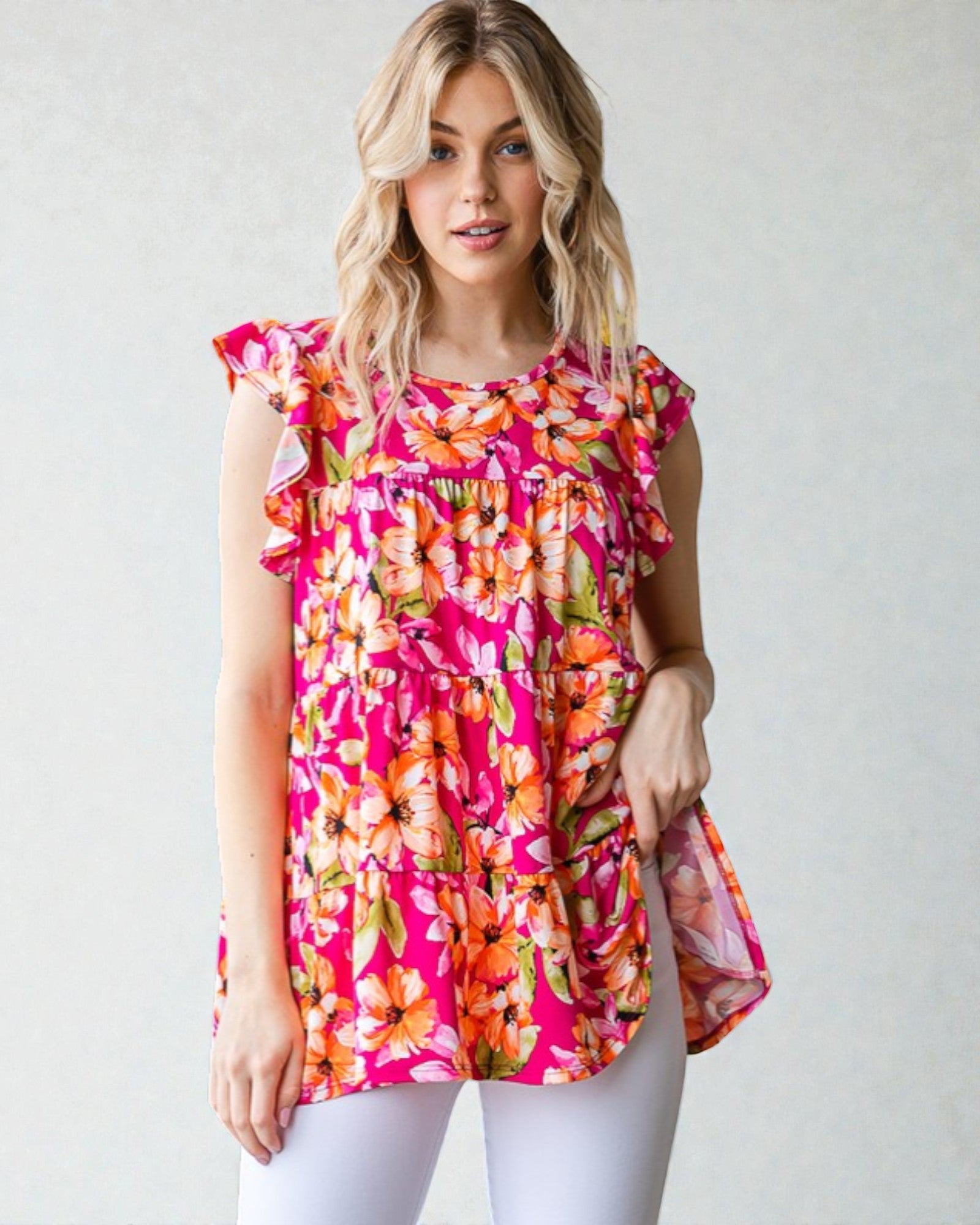 Woman wearing a colorful floral blouse against a plain background