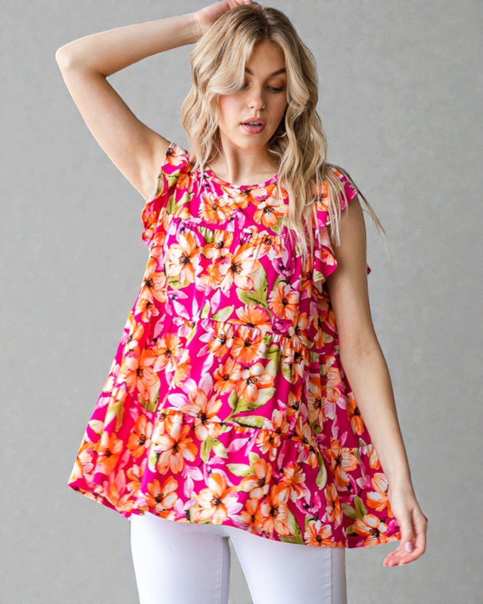 Woman wearing a colorful floral dress against a gray background