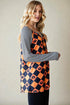 Woman wearing a Halloween-themed dress with black and orange checkered pattern and ghost design.