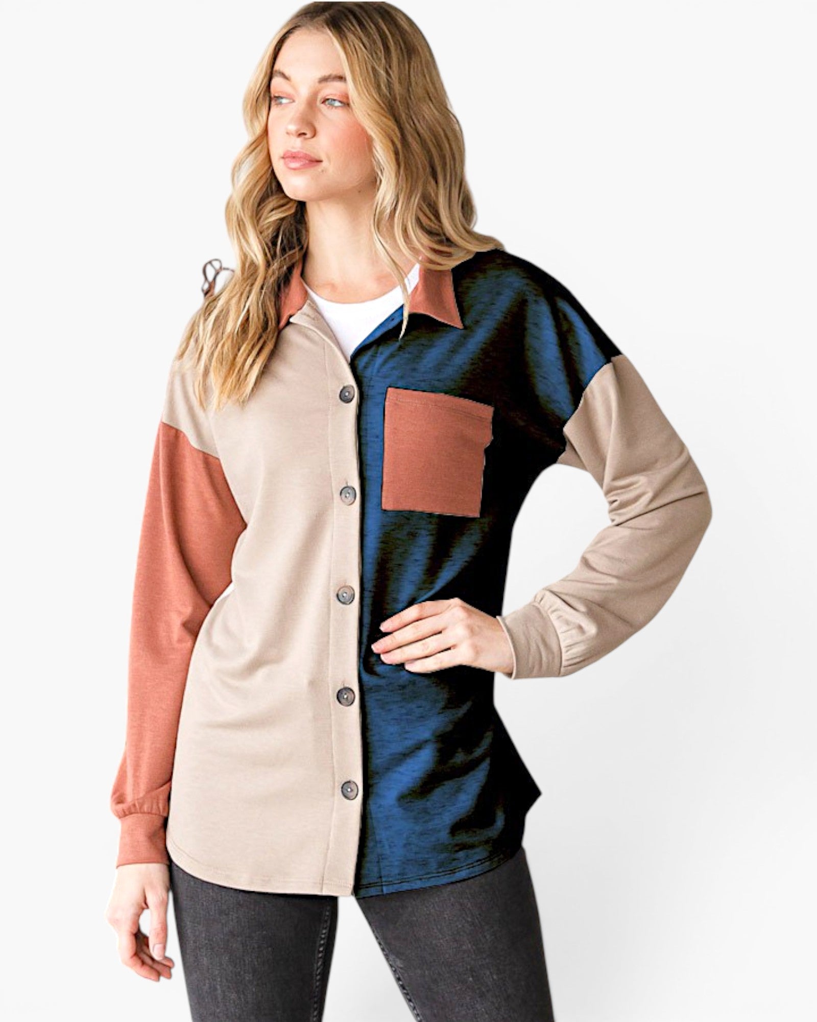 A woman modeling a color-block button-up shirt with beige, dark blue, and terracotta panels, paired with dark gray jeans against a plain white background.