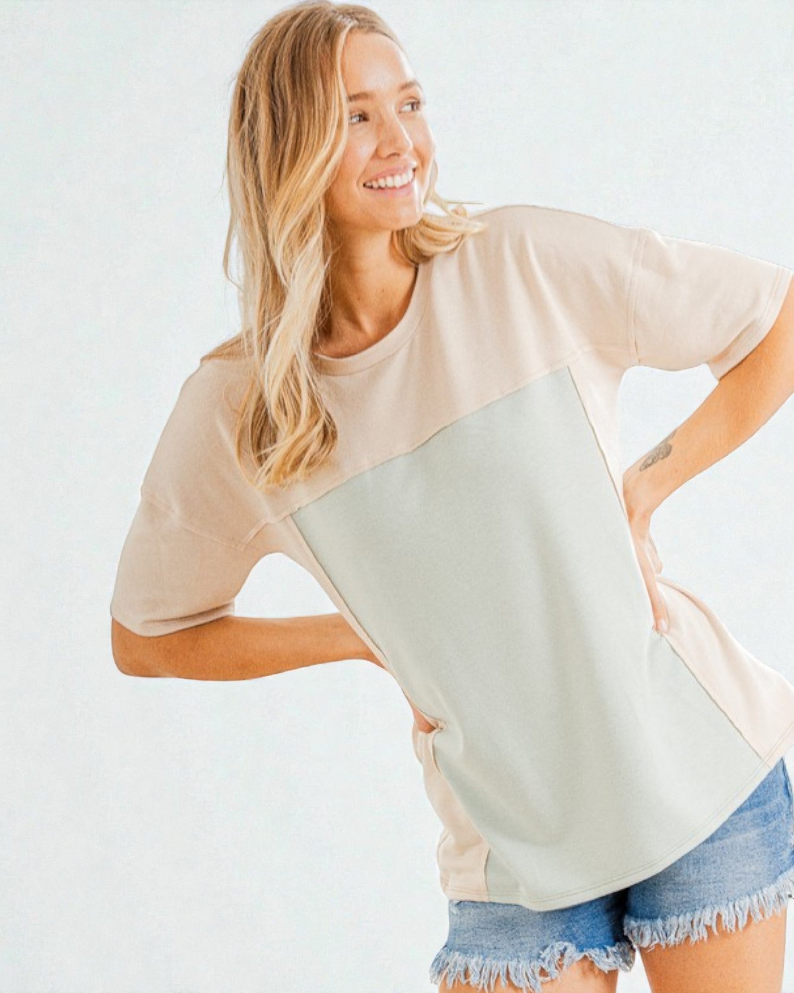 Woman wearing a color-blocked t-shirt with a plain background
