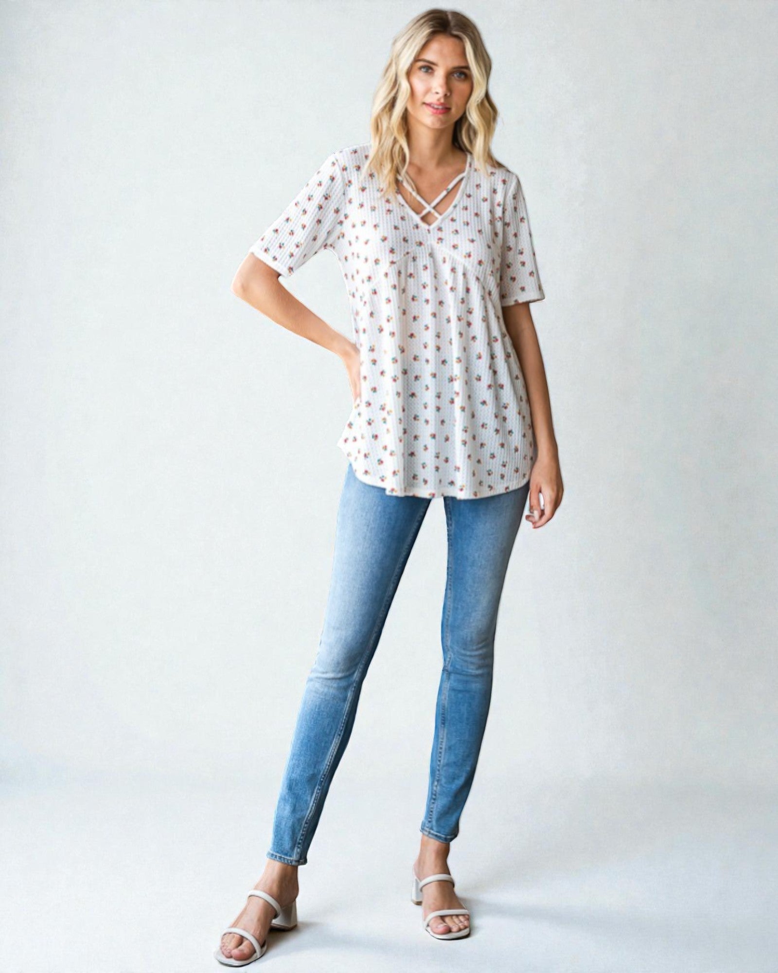 Woman wearing a patterned blouse and blue jeans on a white background