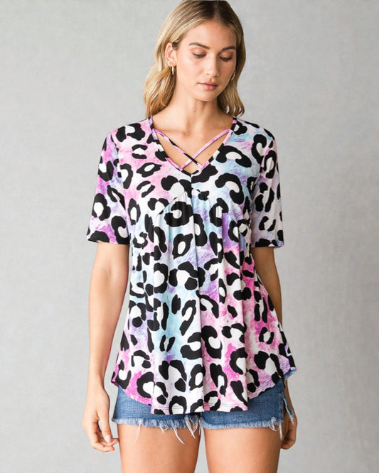 Woman wearing a colorful leopard print top with a gray background