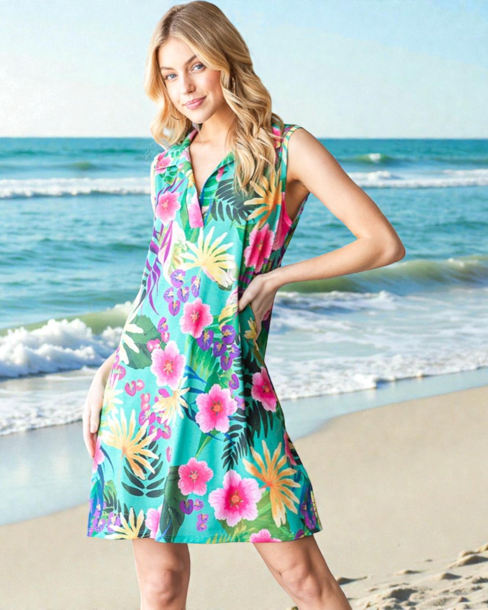 Woman wearing a colorful floral dress on a beach with ocean waves in the background