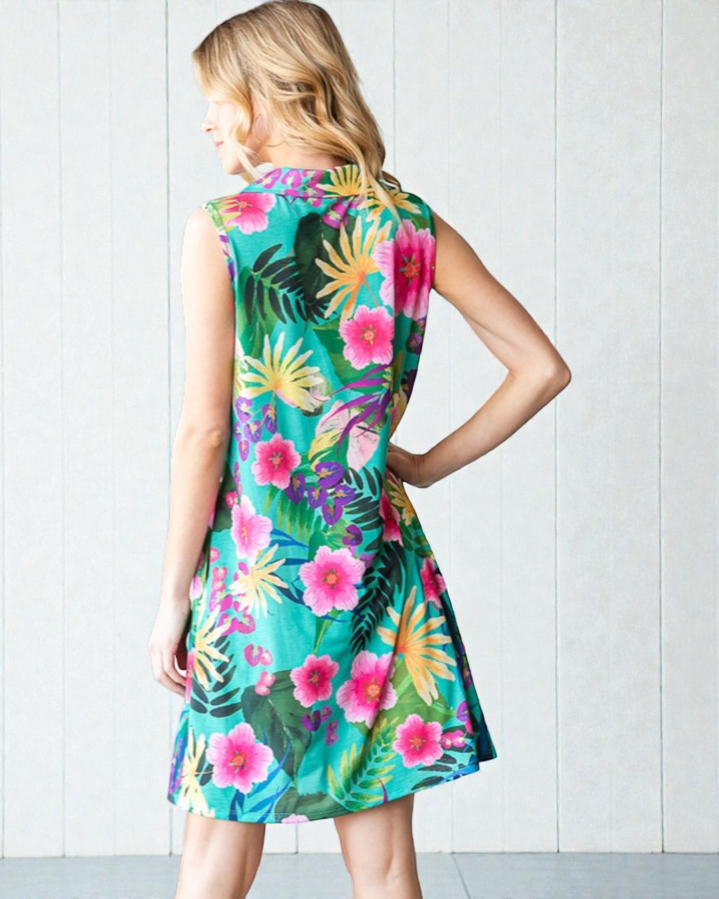 Woman wearing a colorful tropical dress against a white background