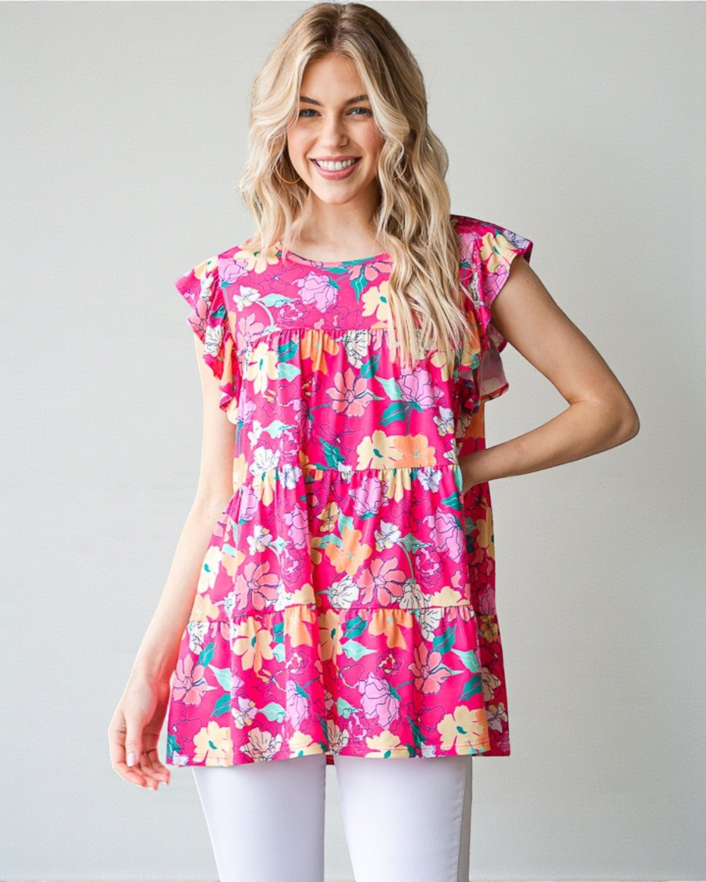 Woman wearing a pink floral dress against a plain background