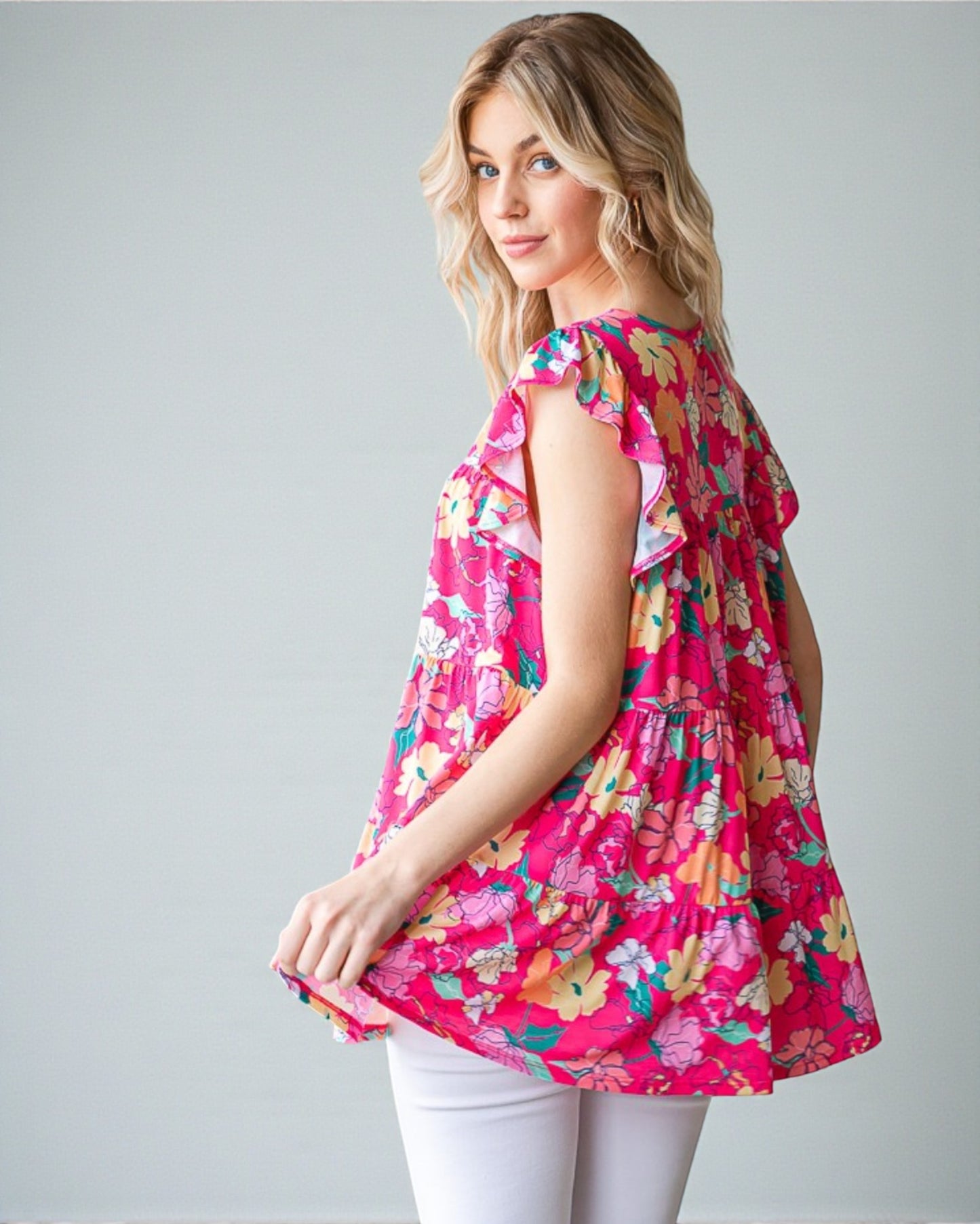 Woman wearing a pink floral dress against a gray background