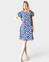Woman wearing a colorful floral dress on a white background