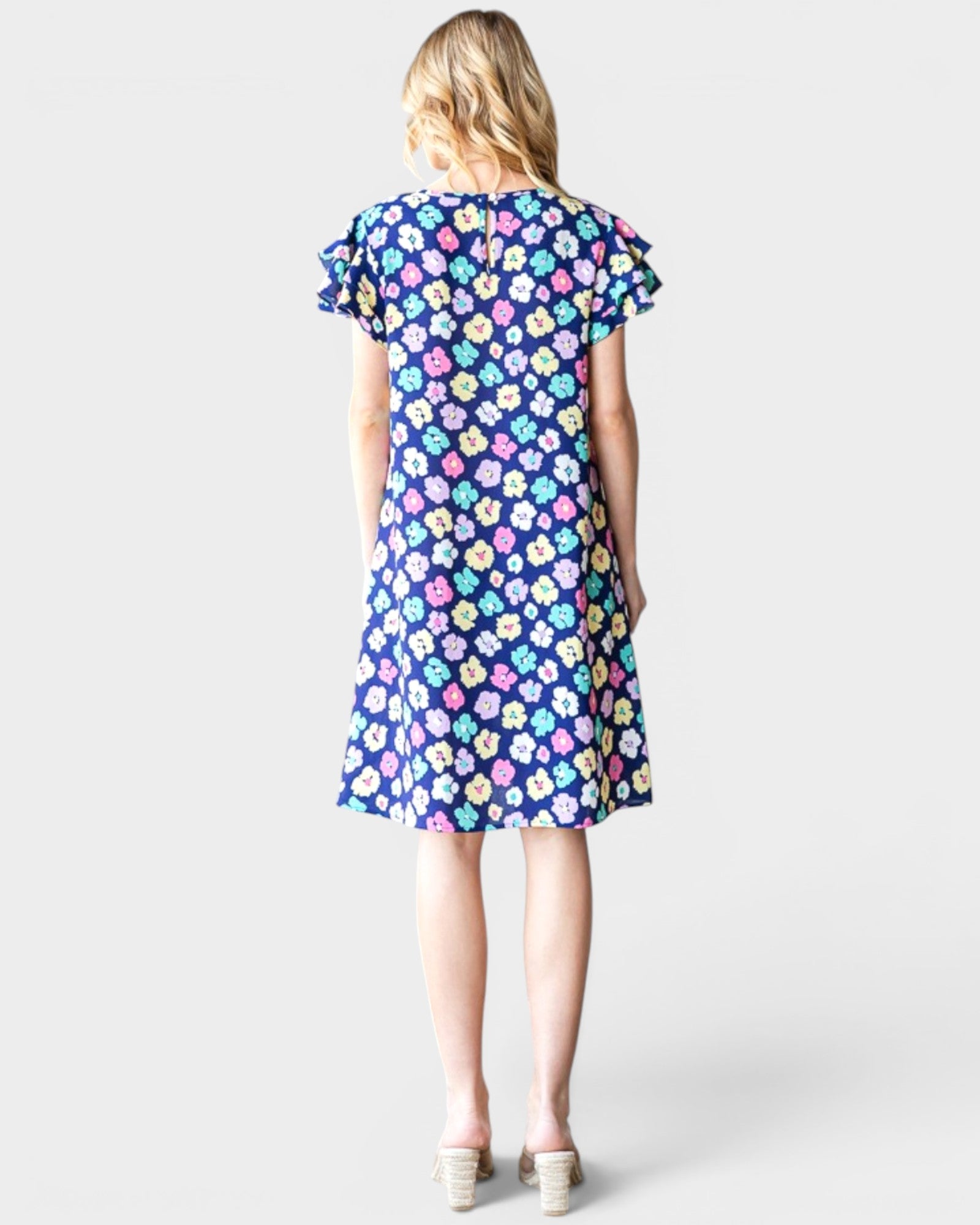 Woman wearing a colorful floral dress on a white background