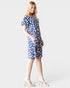 Woman wearing a colorful floral dress on a white background