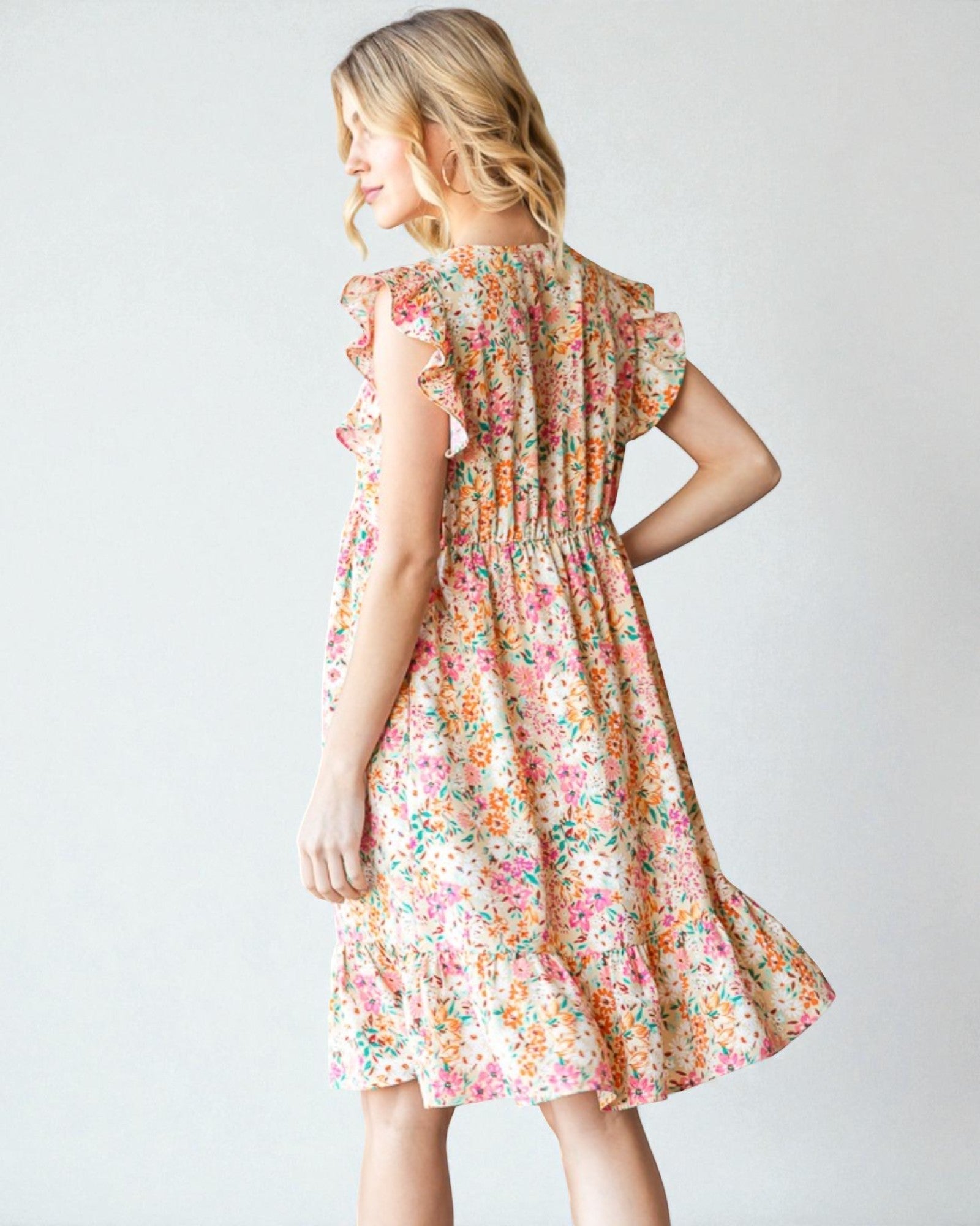 Woman wearing a floral dress against a plain background