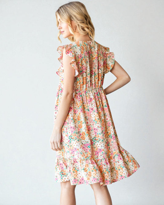 Woman wearing a floral dress against a plain background