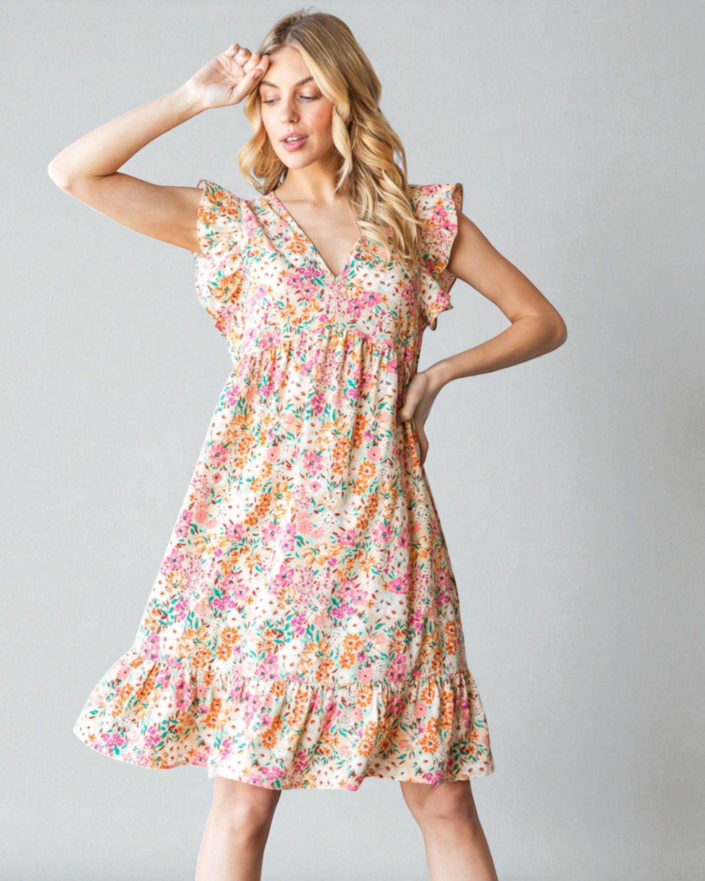 Woman wearing a floral dress against a plain background