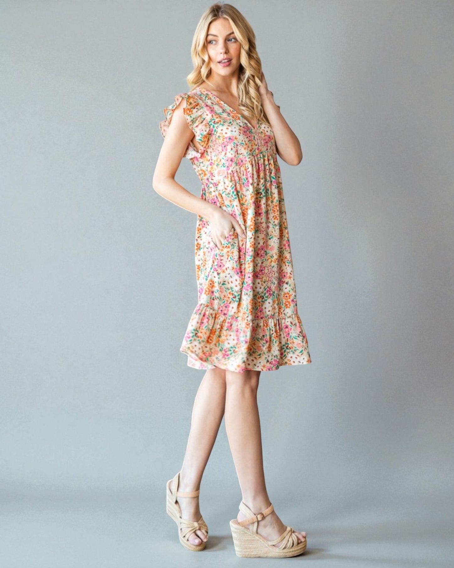 Woman wearing a floral dress against a gray background