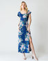 Woman wearing a blue floral dress against a white background