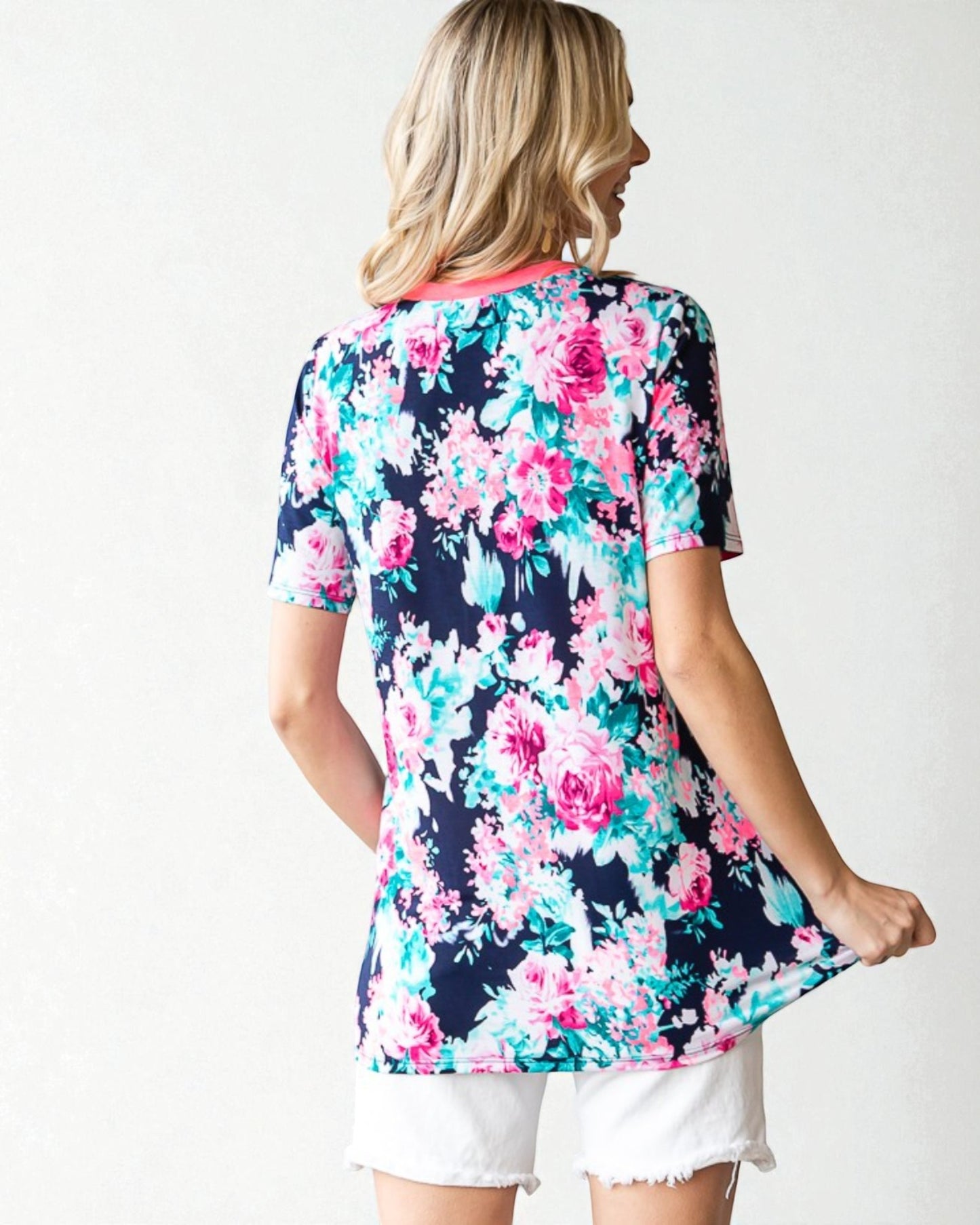 Woman wearing a floral patterned shirt with a white background