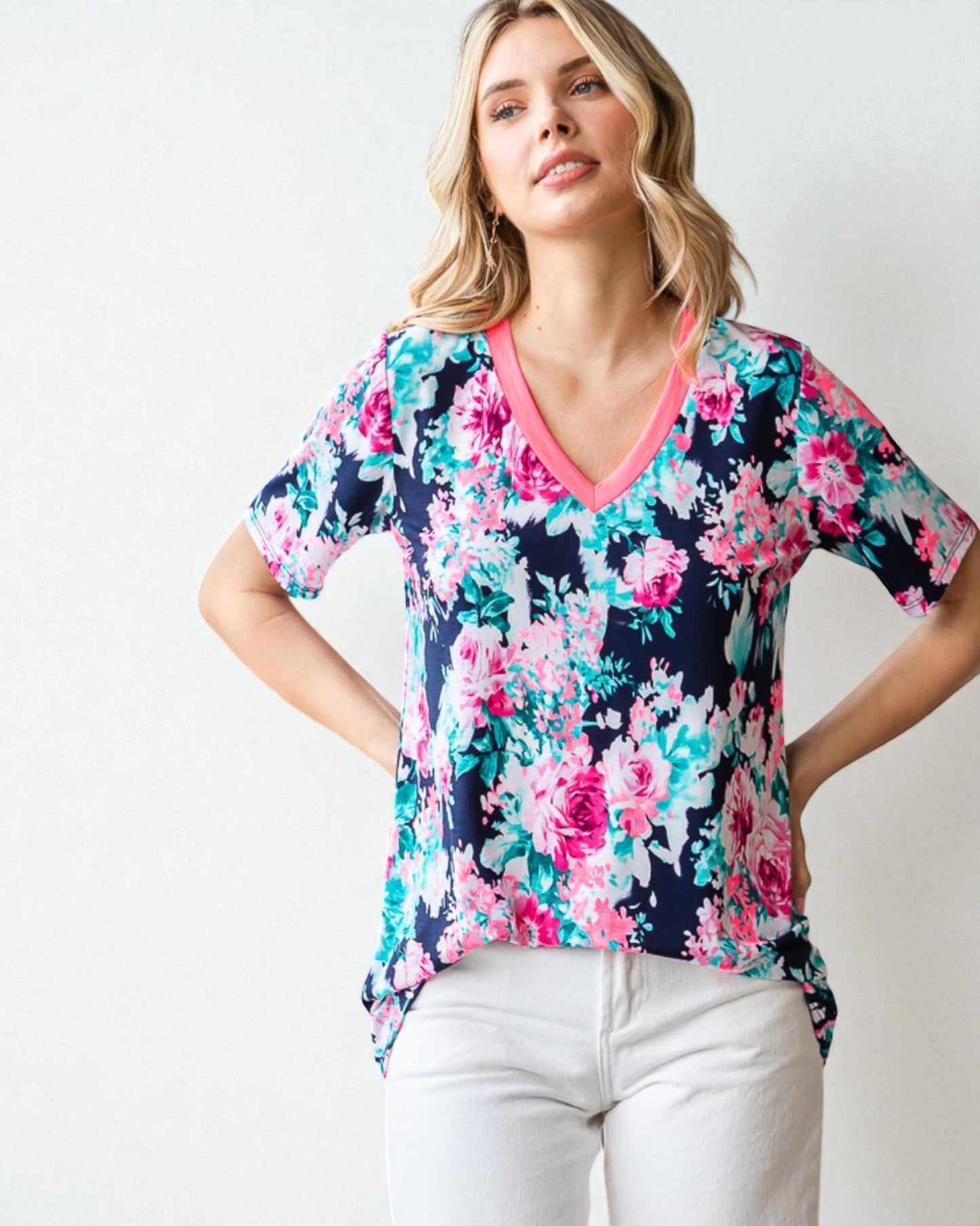 Woman wearing a colorful floral blouse with a plain background
