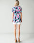 Woman wearing a floral dress with a plain background