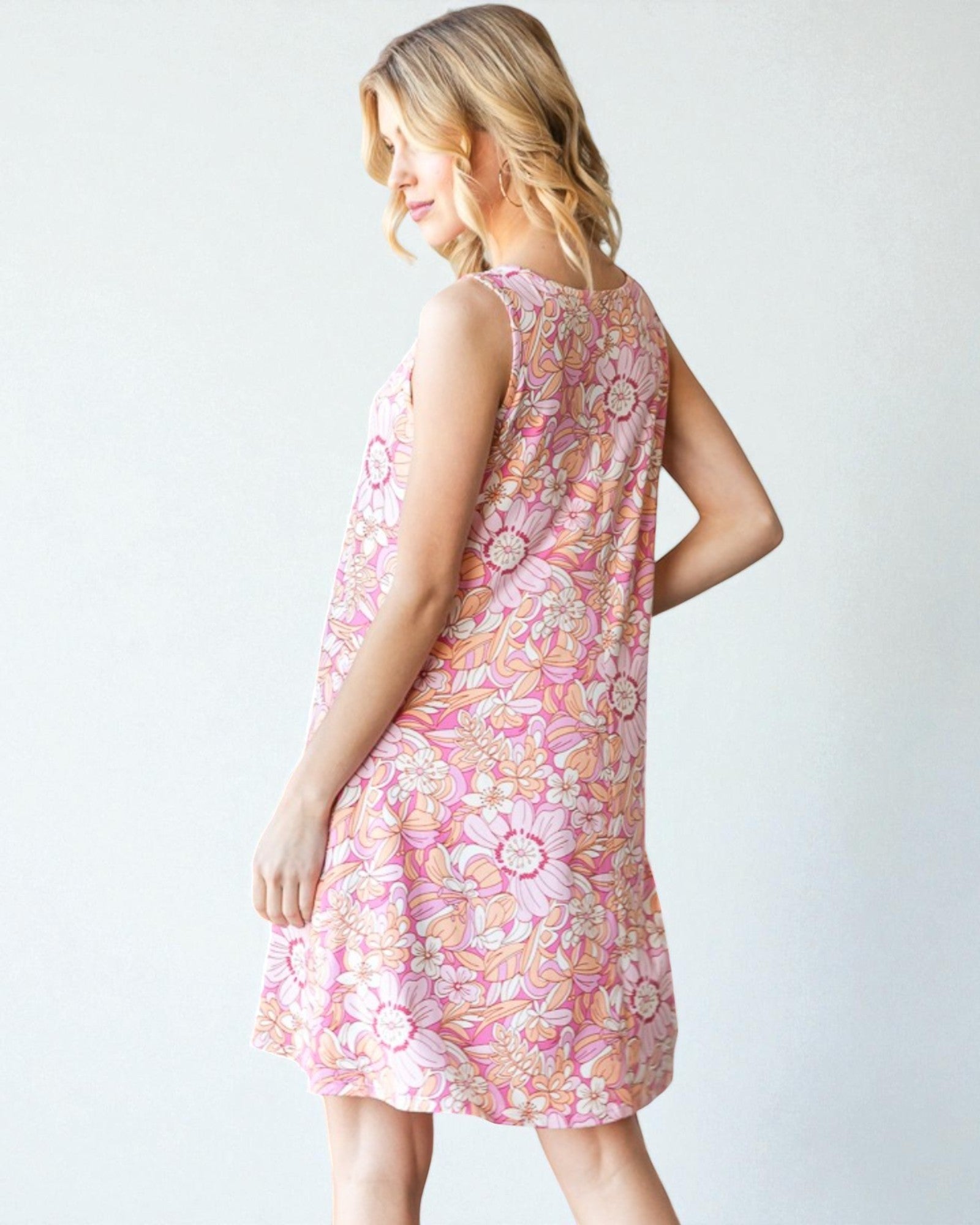 Woman wearing a pink floral dress against a white background
