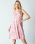 Woman wearing a pink floral dress against a white background