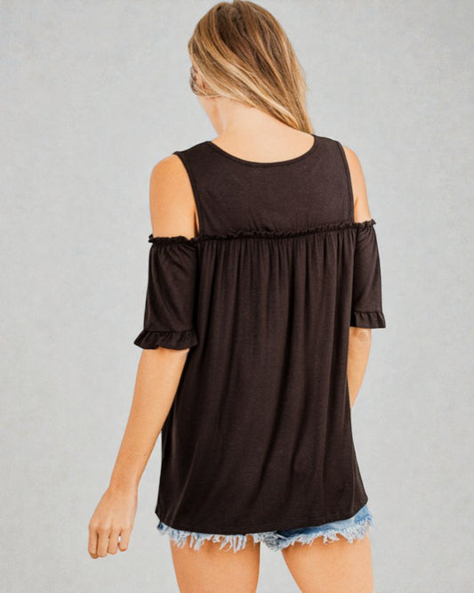 Woman wearing a black off-shoulder top with ruffled sleeves on a gray background