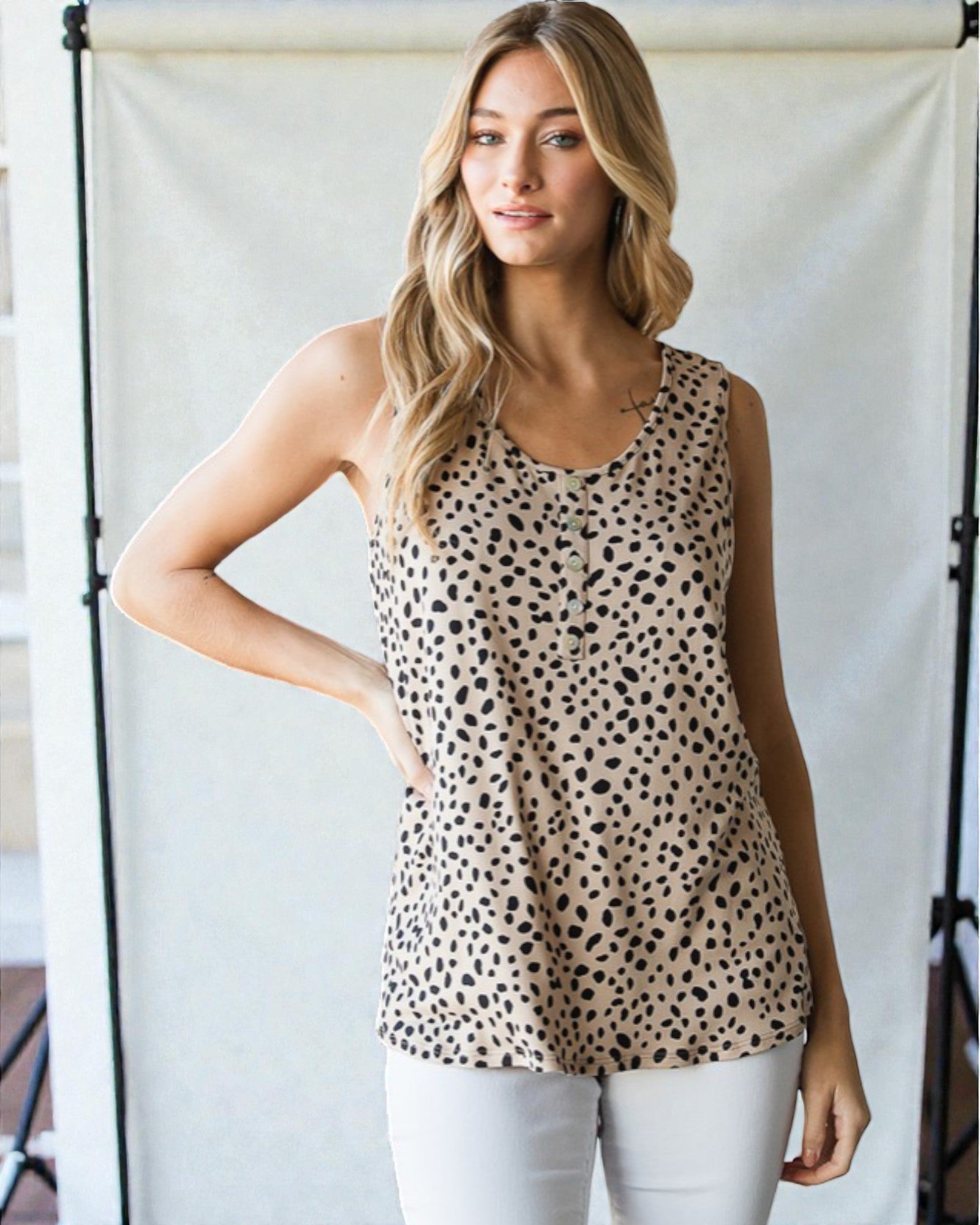 Woman wearing a leopard print tank top against a neutral background